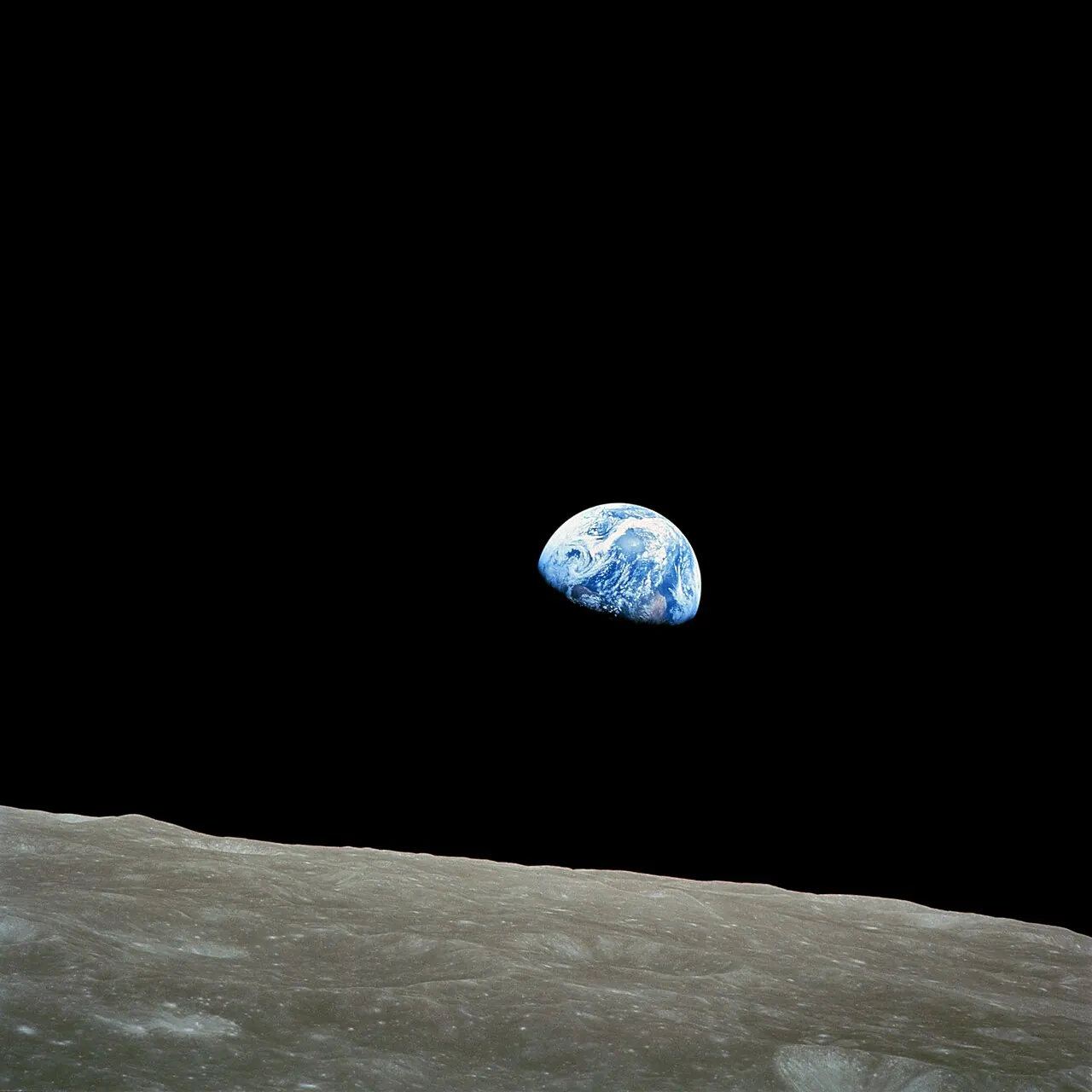 Earthrise: the half-lit Earth rising above the gray lunar horizon, photographed by Apollo 8 astronauts in December 1968.