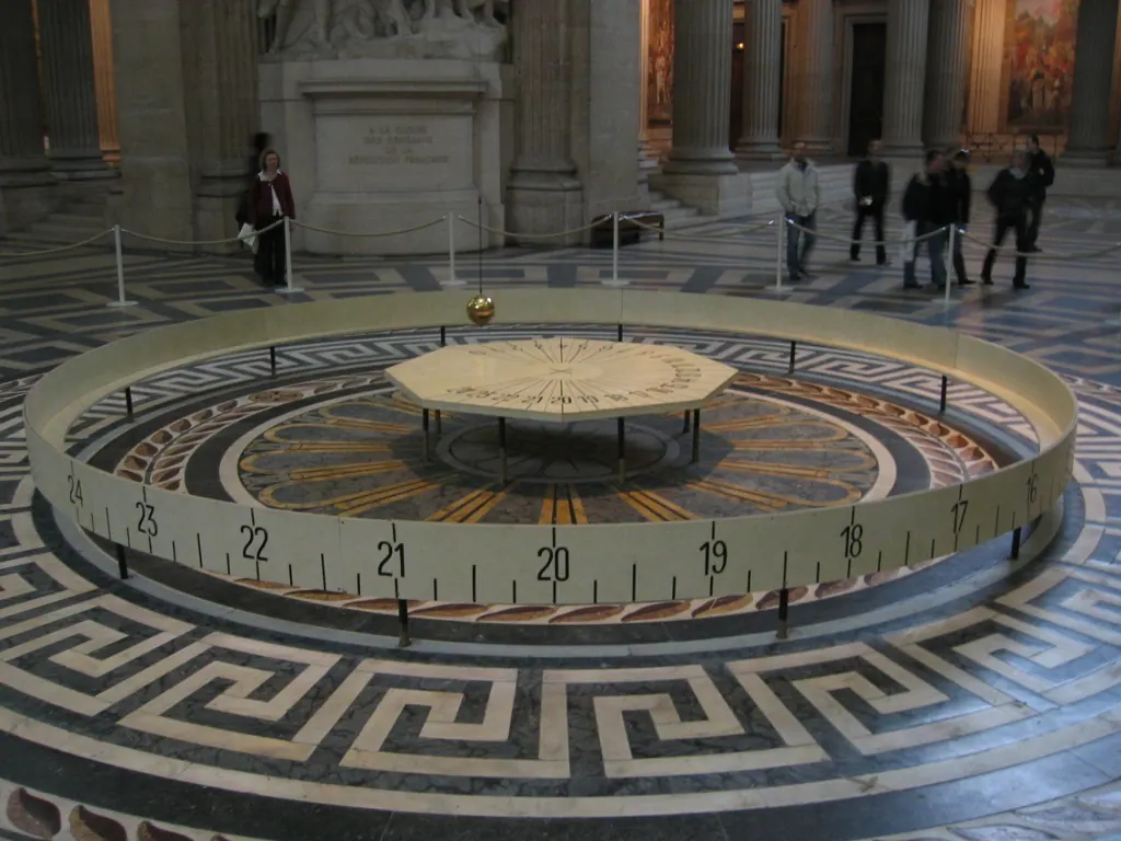 The Foucault pendulum in the Pantheon in Paris: a heavy bob on a long wire swinging above a circular scale on the floor.