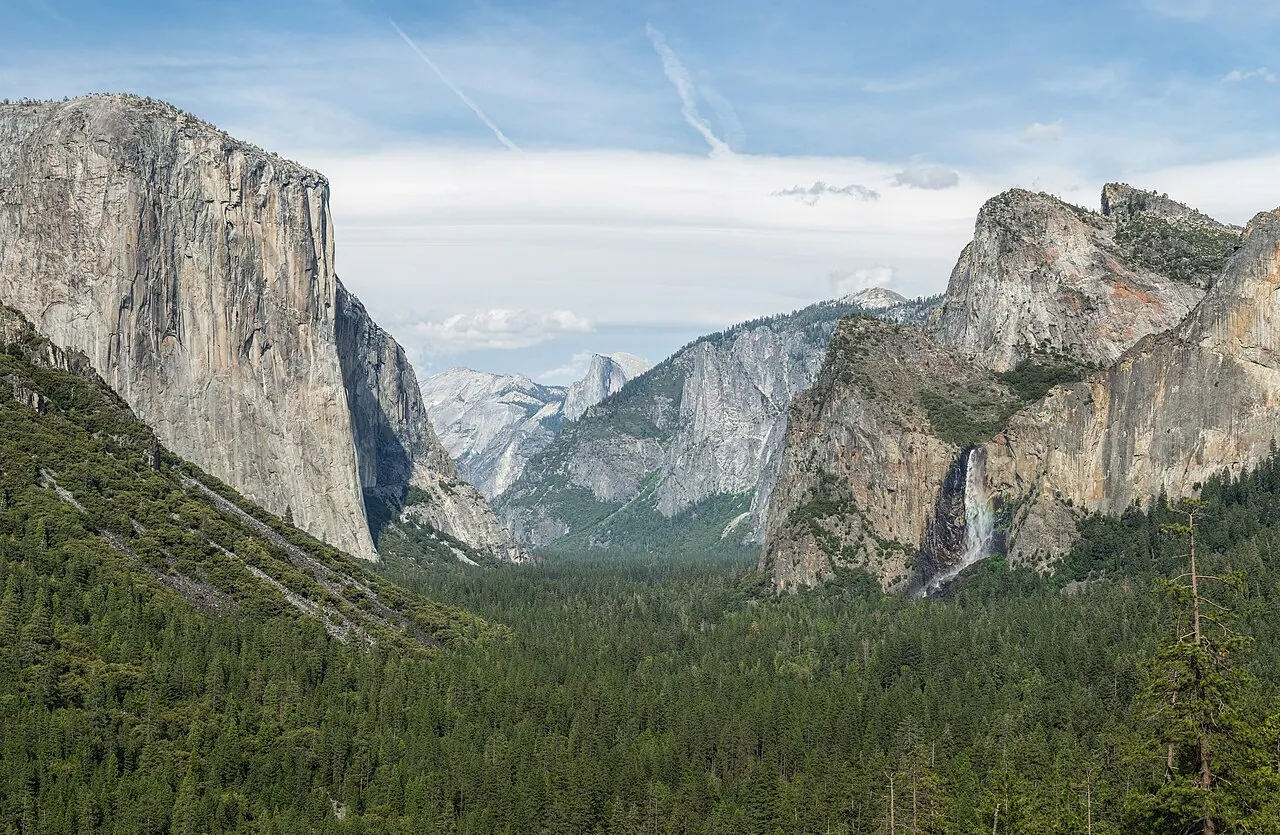 Yosemite Valley from Tunnel View: sheer granite walls including El Capitan and Half Dome rising above a broad, flat-floored, U-shaped valley.